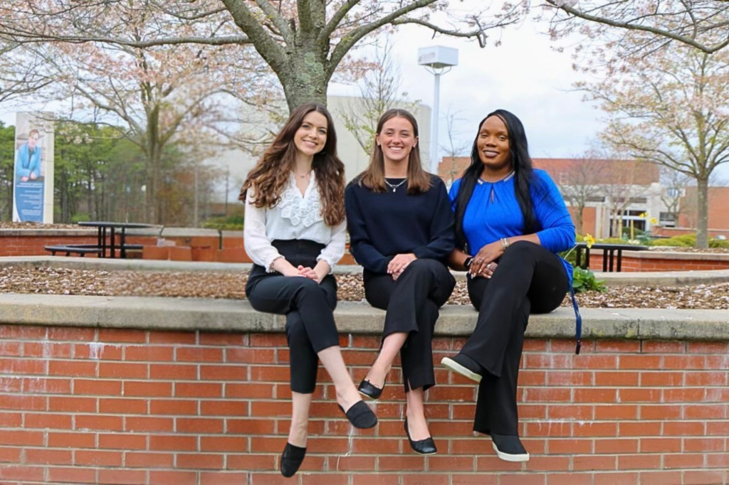 Student Success Coaches sitting on the wall in the campus mall